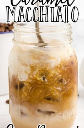 close up side shot of Iced Caramel Macchiato in a glass jar with ice being stirred with a spoon