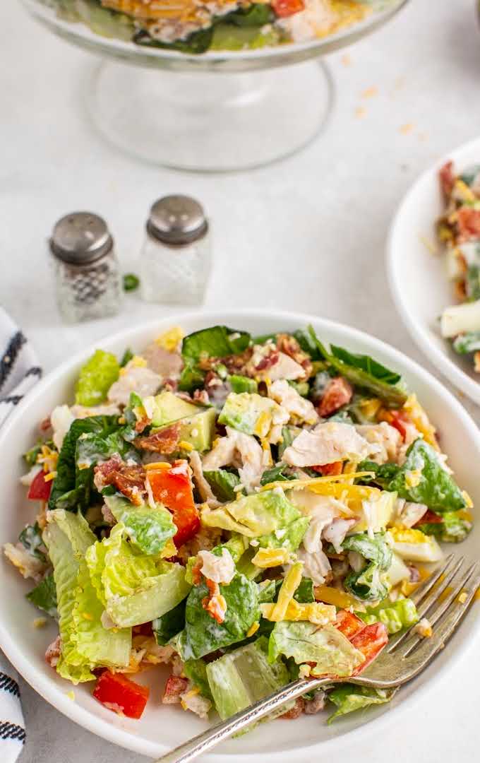 chicken bacon ranch salad with ranch dressing on a plate with a fork