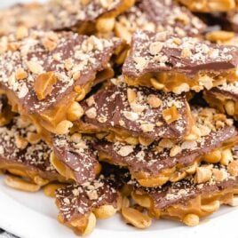a close up shot of Chocolate Peanut Toffee stacked on top of each other on a plate
