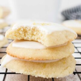 Lemon Meltaway Cookies piled on top of each other on a cooling rack