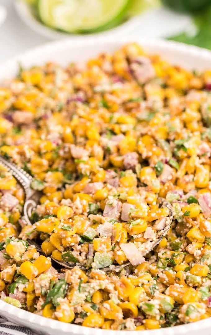 close up overhead shot of Mexican corn salad being picked up with a spoon in a bowl