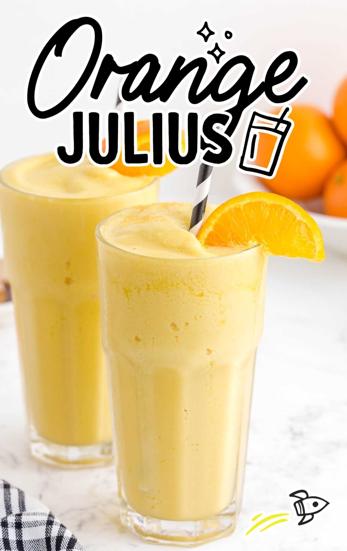 orange julius in glasses with a stripped straw garnished with a slice of orange
