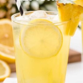 close up shot of a glass of Pineapple Lemonade with a slice of pineapple and lemon