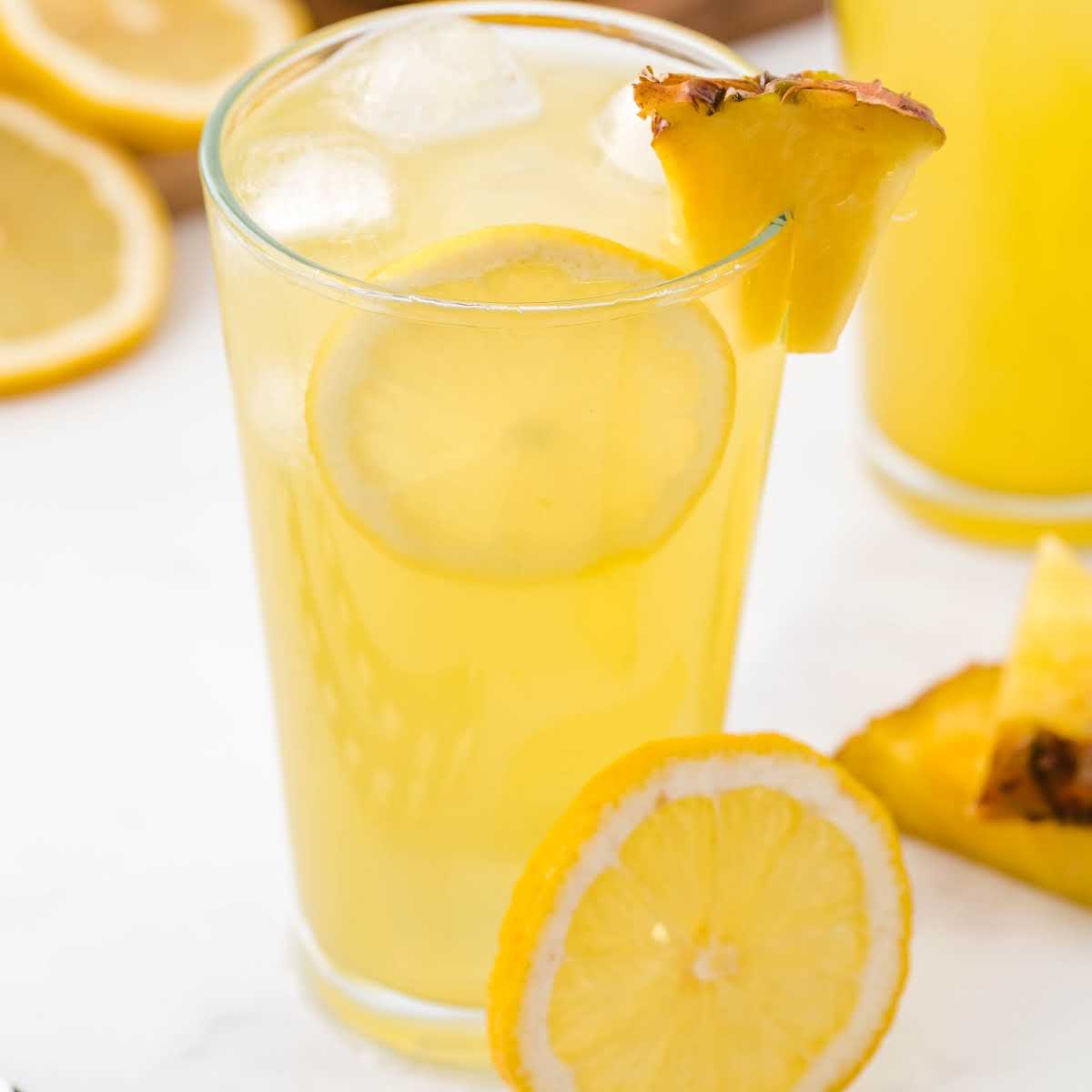 close up shot of a glass of Pineapple Lemonade with a slice of pineapple and lemon