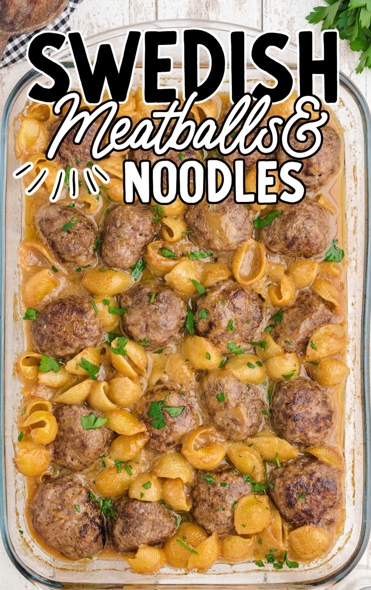 swedish meatballs and noodles garnished with parsley in a baking dish