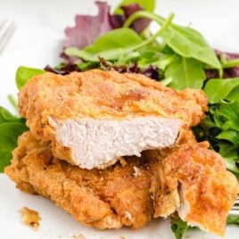 Fried Pork Chops on a plate with a side of salad