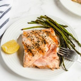 grilled salmon on a plate with asparagus and a slice of lemon