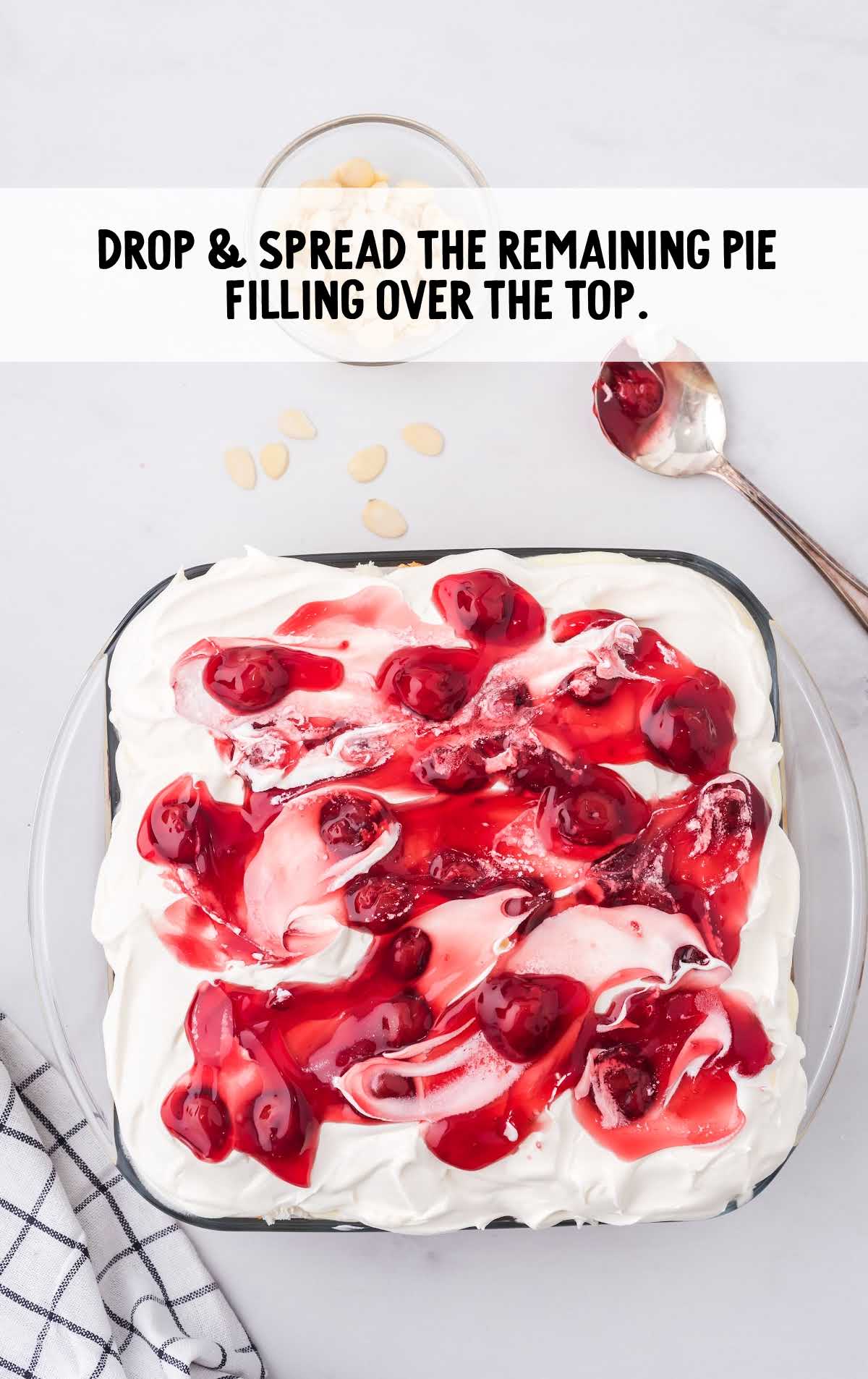 cherry filling being spread over cake