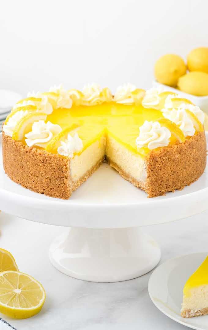 lemon cheesecake on a cake serving tray with a slice missing