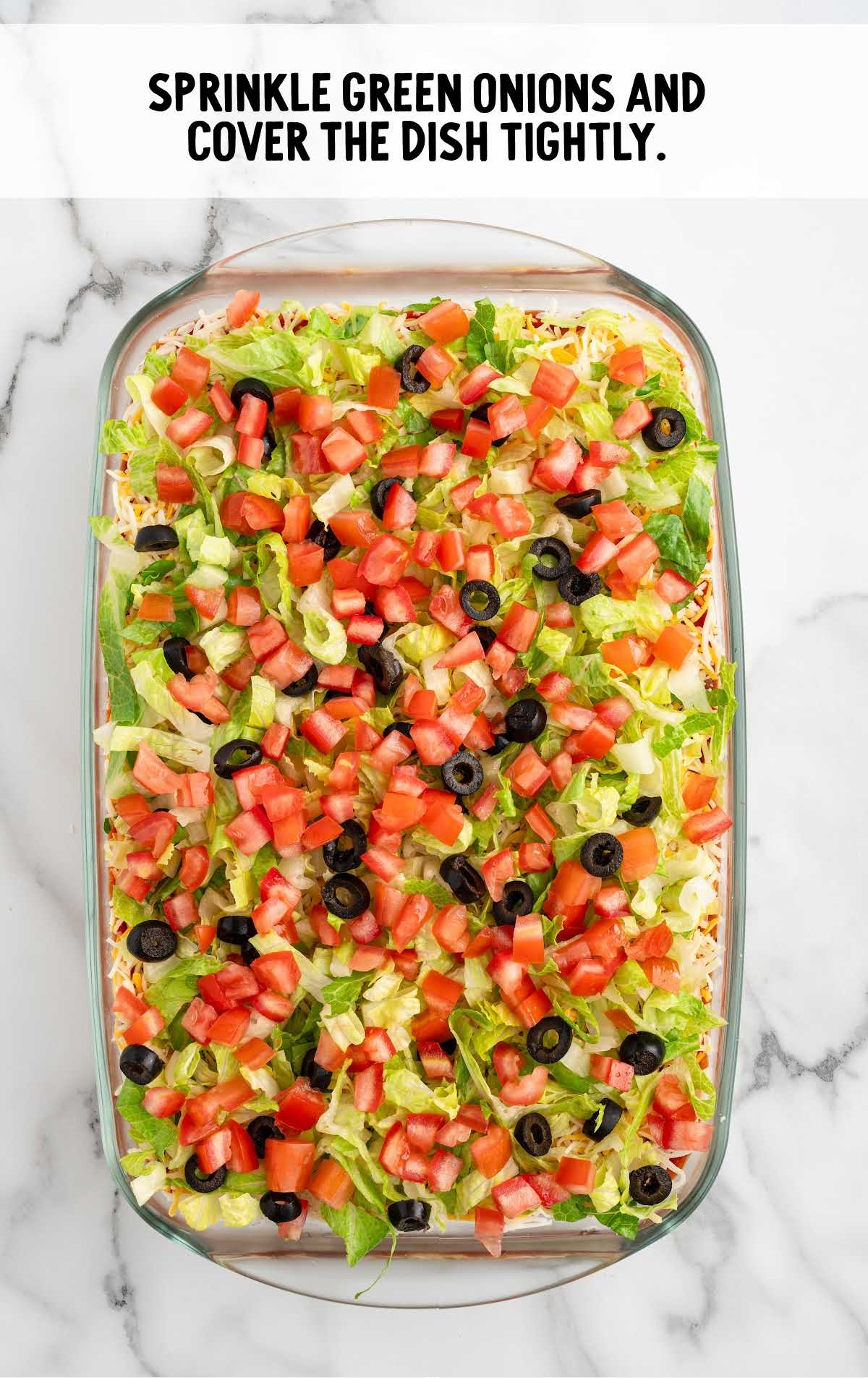 green onions sprinkled on top of the 7 Layer Dip