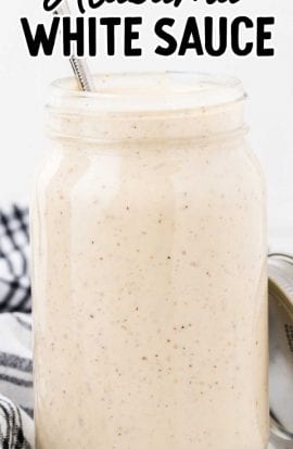 close up shot of Alabama white sauce in a mason jar with a spoon