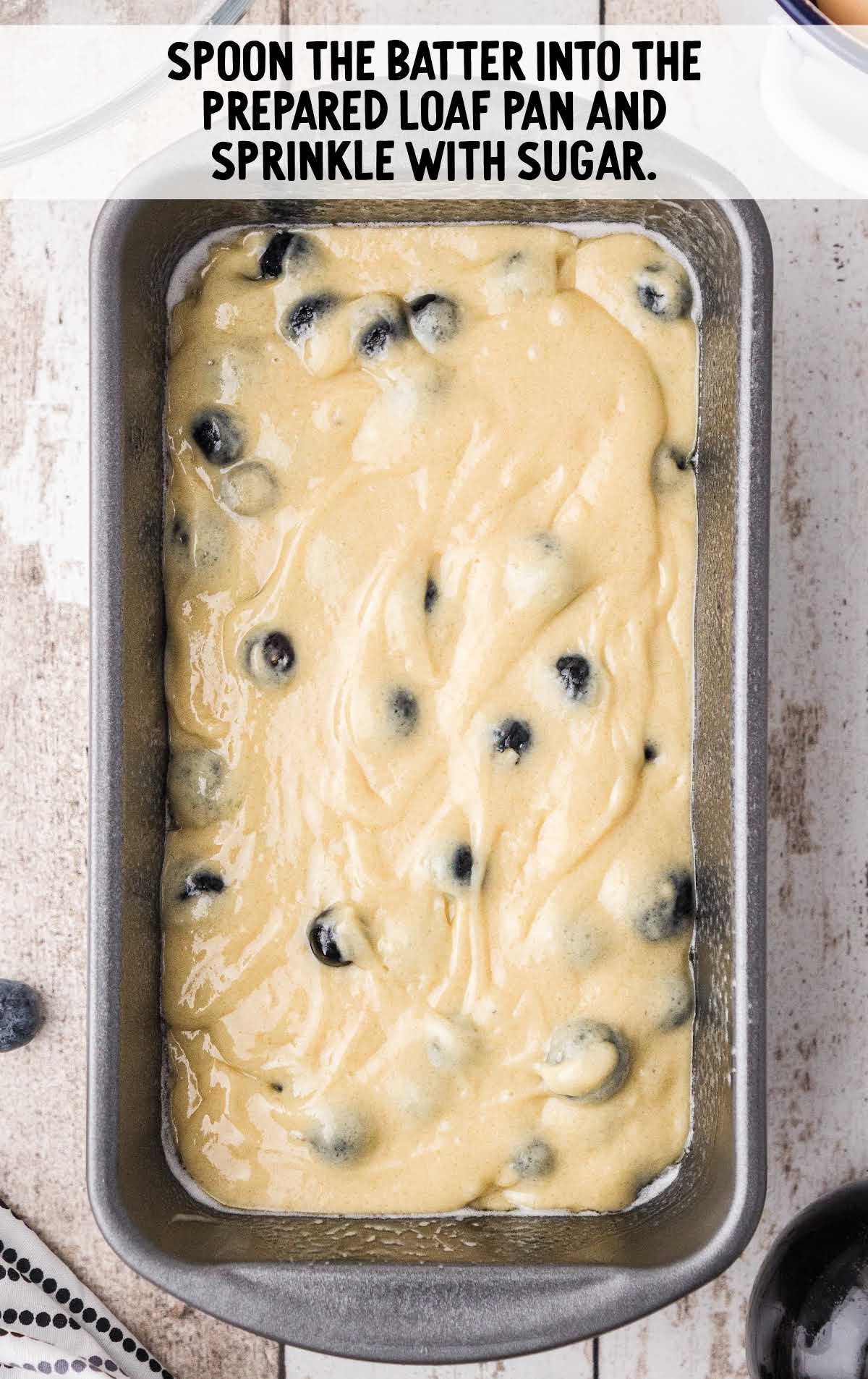 blueberry bread process shot of butter being spread on the top of blueberry bread