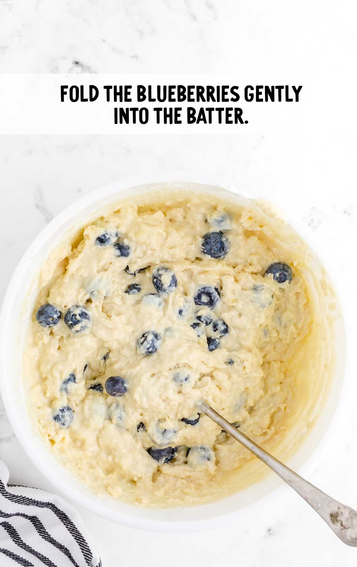 blueberry muffins with sour cream prices shot of blueberries added into batter in a bowl