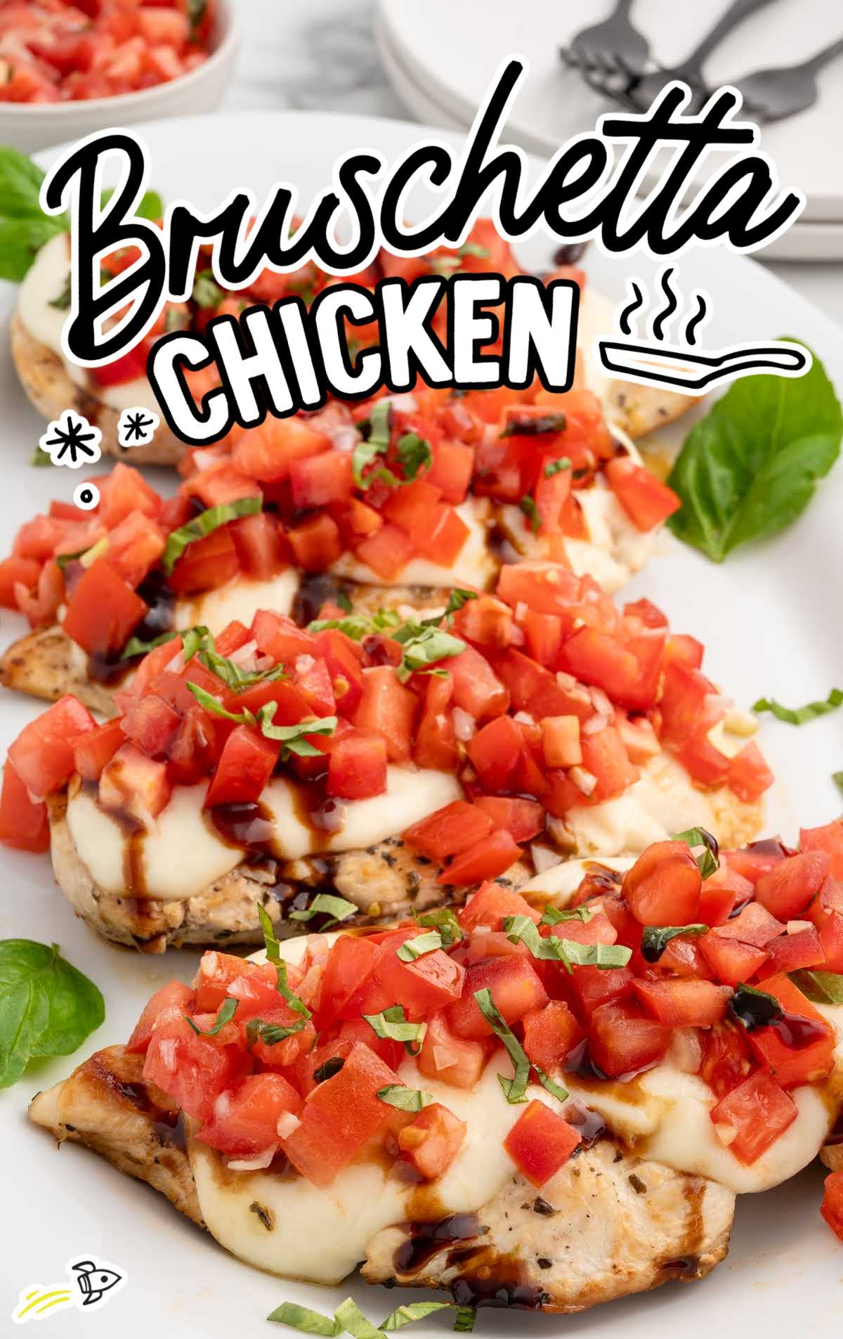 Bruschetta Chicken topped with basil on a serving tray