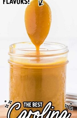 close up shot of Carolina mustard BBQ sauce in a mason jar with the sauce being picked up with a spoon