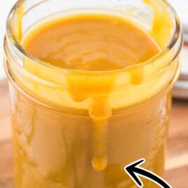 close up shot of Carolina mustard BBQ sauce in a mason jar with the sauce