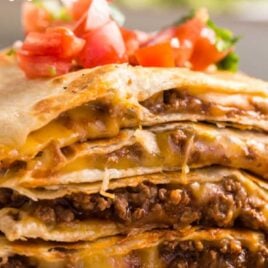 close up shot of a plate of Cheesy Beef Quesadillas topped with salsa