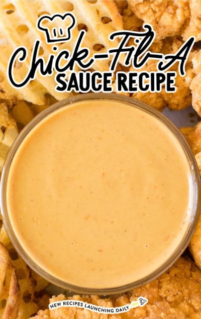 close up shot of copycat chick fil a sauce in a condiment cup with chicken tenders and fries
