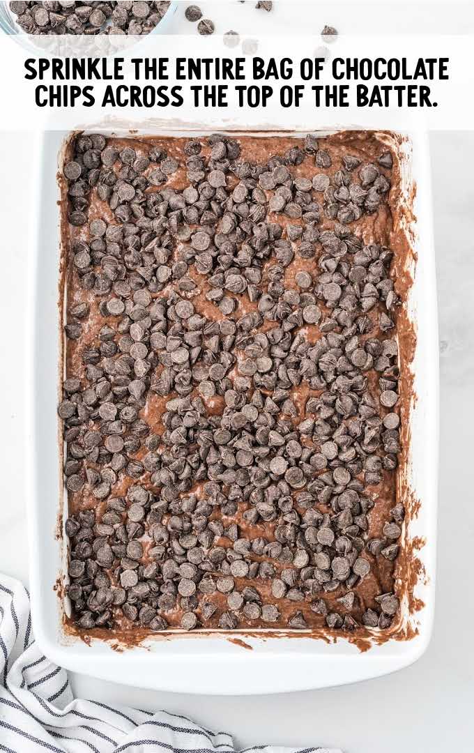 chocolate chip being poured on top of cake mixture in a pan