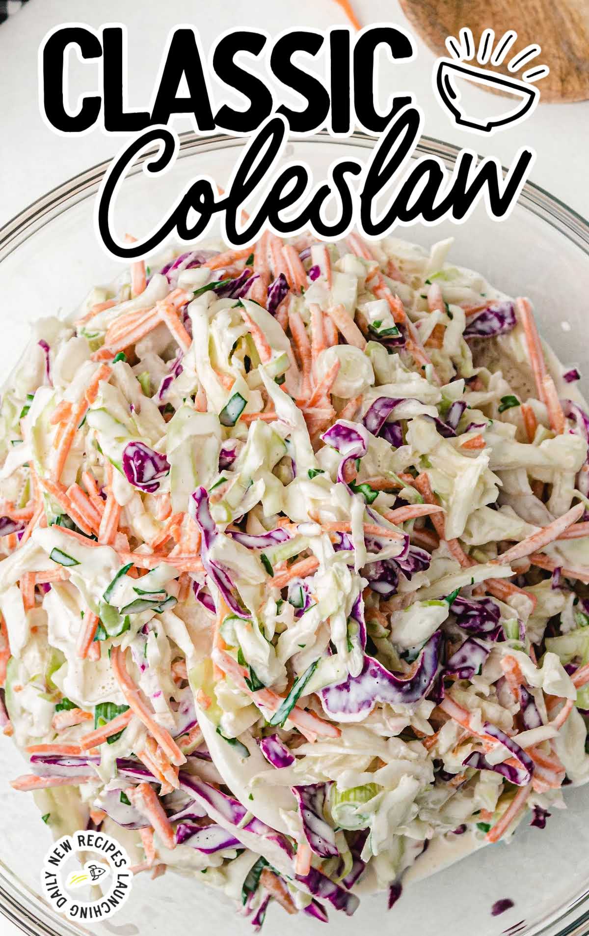 close up shot of classic coleslaw topped with homemade salad dressing in a white bowl