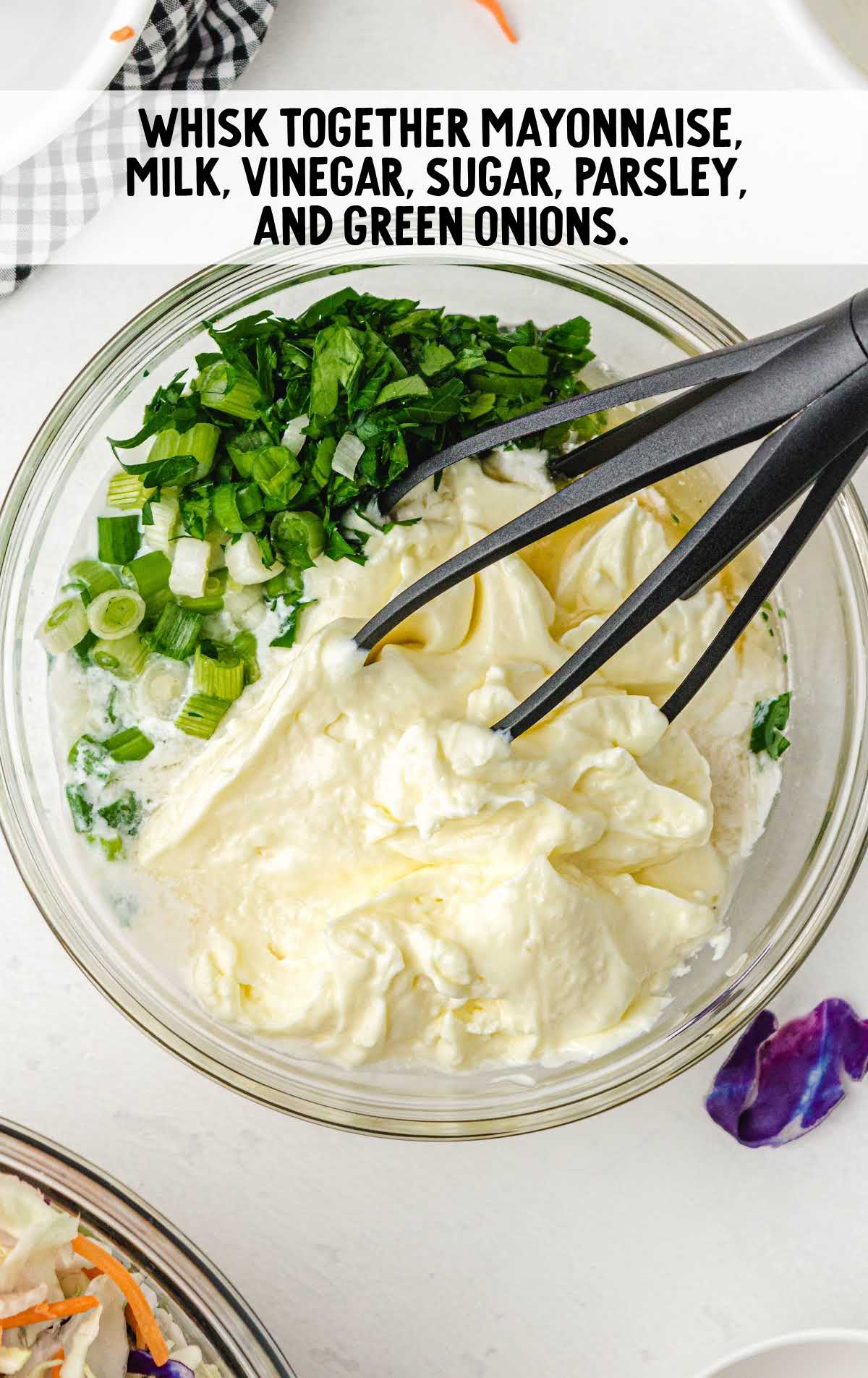 mayonnaise, milk, vinegar, sugar, parsley, and green onions whisked together in a bowl