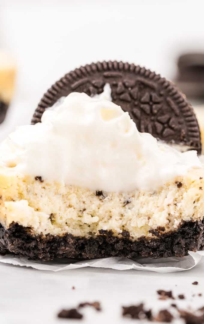 cookies and cream cheesecakes with a Oreo cookie on top with a piece taken out of it