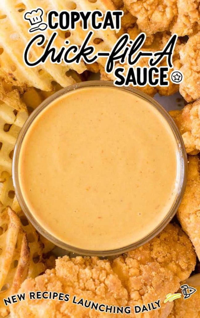 close up shot of copycat chick fil a sauce in a condiment cup with chicken tenders and fries