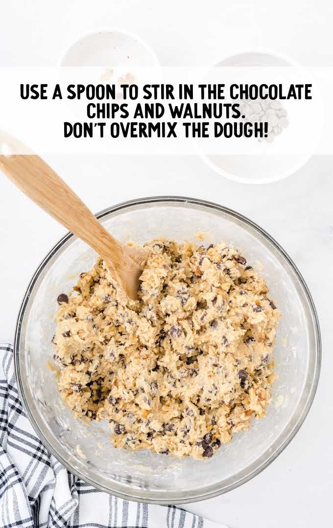 chocolate chips and walnuts combined to the cookie batter in a bowl
