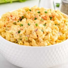 close up shot of egg pasta salad in a bowl garnished with chopped green onions