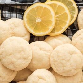 close up overhead shot of Lemon Sugar Cookies on a cooling rack with slices of lemon