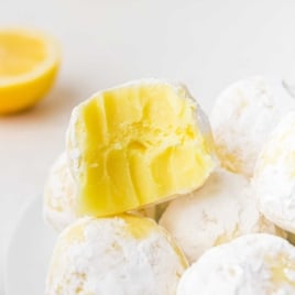 close up shot of white chocolate lemon truffles with a bite taken out of one