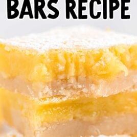 close up side shot of lemon bars stacked on top of each other with one having a bite taken out of it