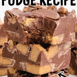 A close up shot of Reese’s Peanut Butter Fudge stacked on top of each other with one having a bite taken out of it