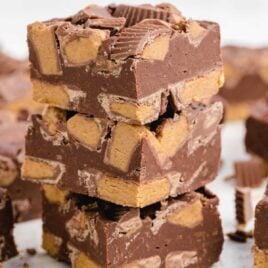 A close up shot of Reese’s Peanut Butter Fudge stacked on top of each other