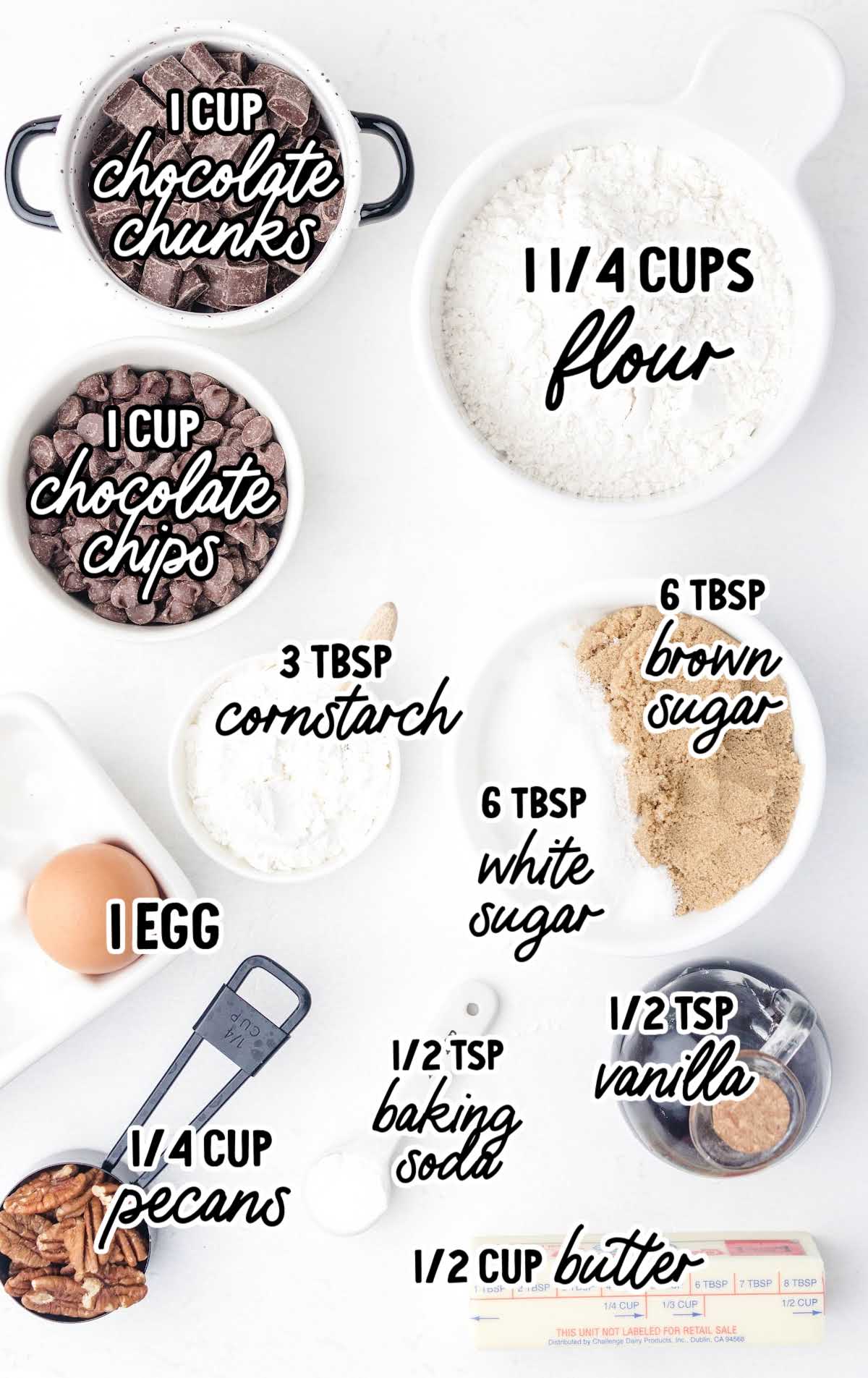 Overhead flat lay of measured cookie ingredients including chocolate chunks, flour, sugar, and pecans.