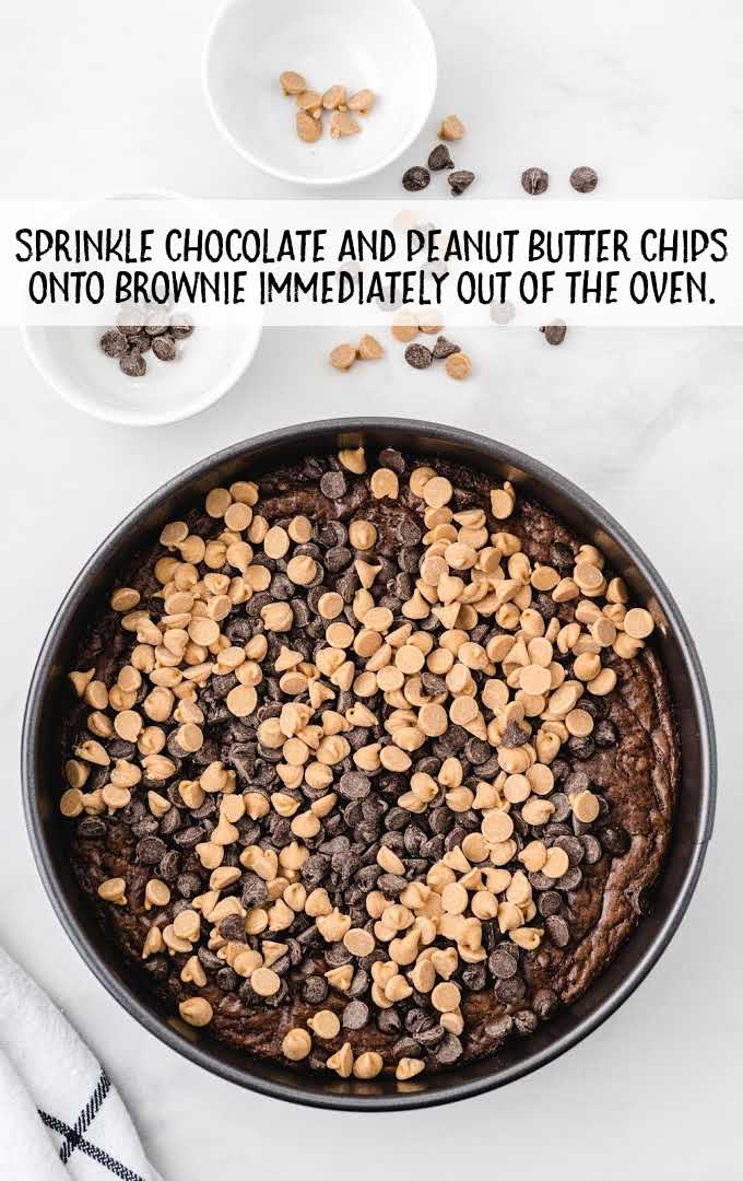 chocolate and peanut butter chips spread on to baked brownie