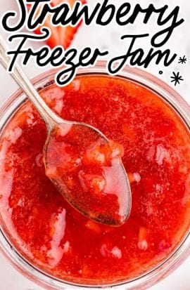 close up overhead shot of strawberry freezer jam in a glass jar with a spoon