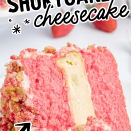 Slice of strawberry shortcake cheesecake with cheesecake center and cookie crumble topping, text overlay reads “The Best Strawberry Shortcake Cheesecake – Creamy Homemade Frosting.”