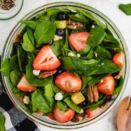 overhead shot of strawberry spinach salad garnished with feta cheese in a bowl