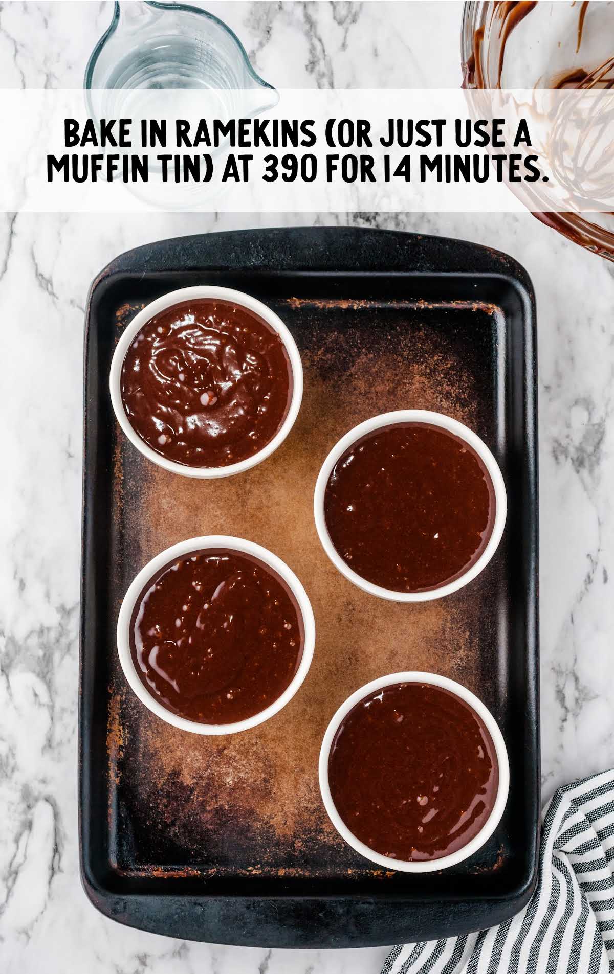 Five white ramekins filled with lava cake batter on a baking tray, ready to bake at 390°F.