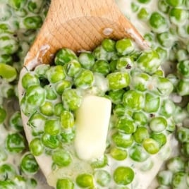 Wooden spoon lifting creamy peas with butter, text overlay reading “Delicious Homemade Creamed Peas – Buttery Recipe!”.