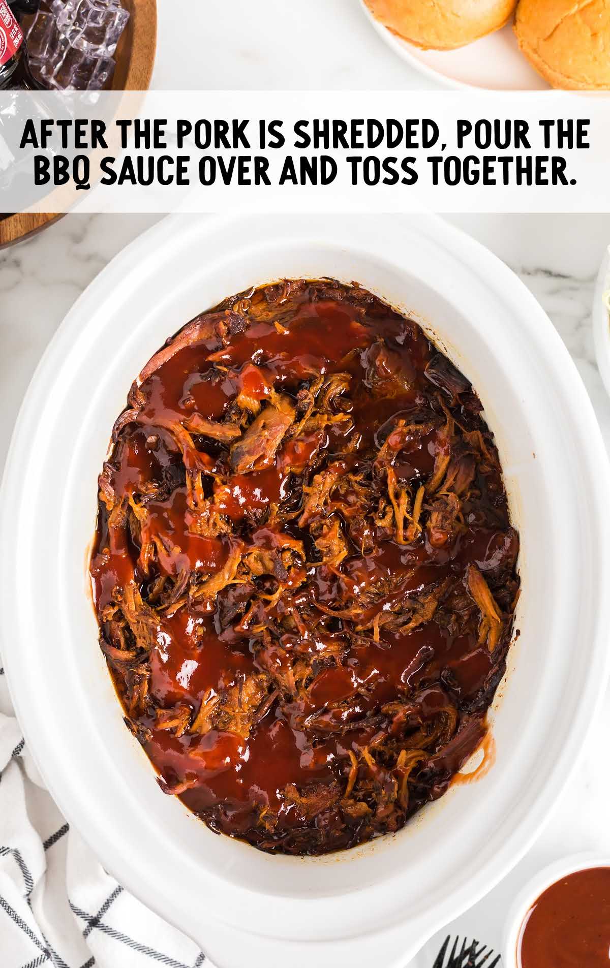 Shredded pulled pork in a slow cooker tossed with barbecue sauce.