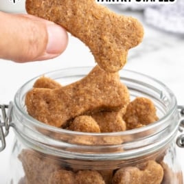 Hand placing a homemade dog treat into a labeled glass jar with text overlay reading “easy homemade dog treats with simple pantry staples.”