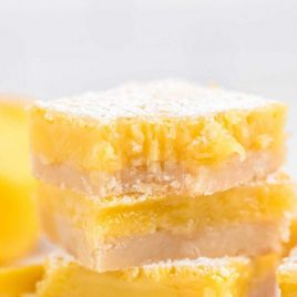 close up side shot of lemon bars stacked on top of each other
