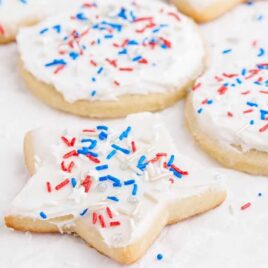 sugar cookies topped with frosting and 4th of July sprinkles
