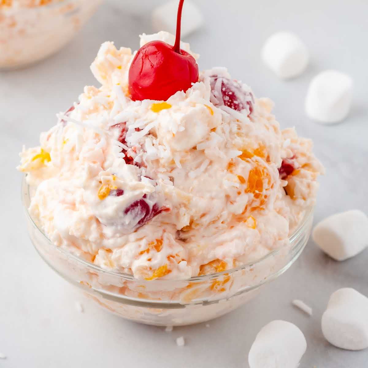 a close up shot of Ambrosia Salad in a clear bowl