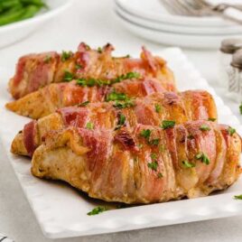 a serving tray of Bacon-Wrapped Chicken garnished with parsley