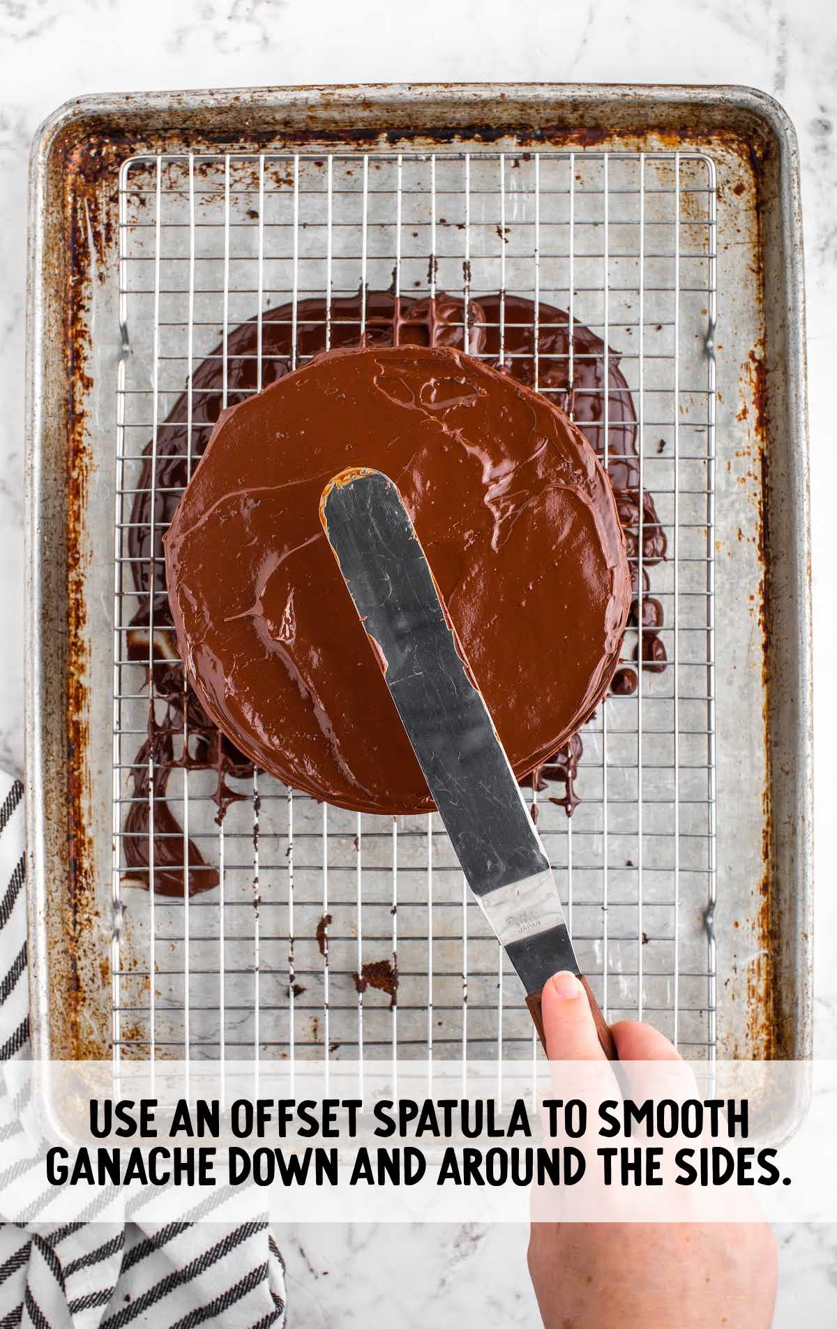 black magic cake process shot of chocolate ganache being spread over cake with a spatula