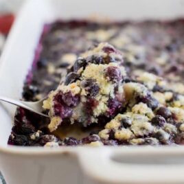 close up shot of Blueberry Cobbler Recipe in a casserole dish with a spoon