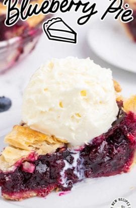 close up shot of a slice of blueberry pie topped with vanilla ice cream on a plate